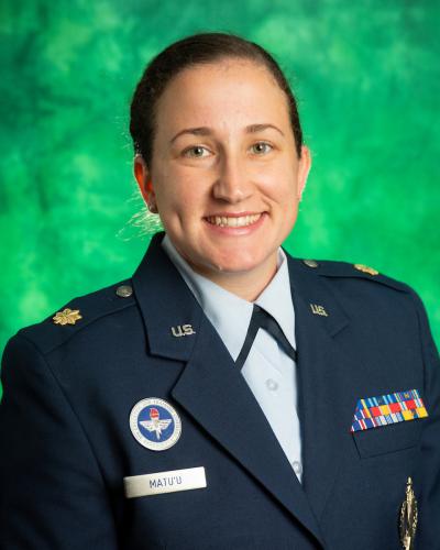 Major Melissa Matu'u posing in front of green background. 